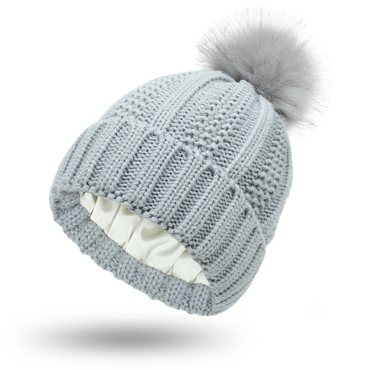 Grofgebreide muts met grote bontpompon