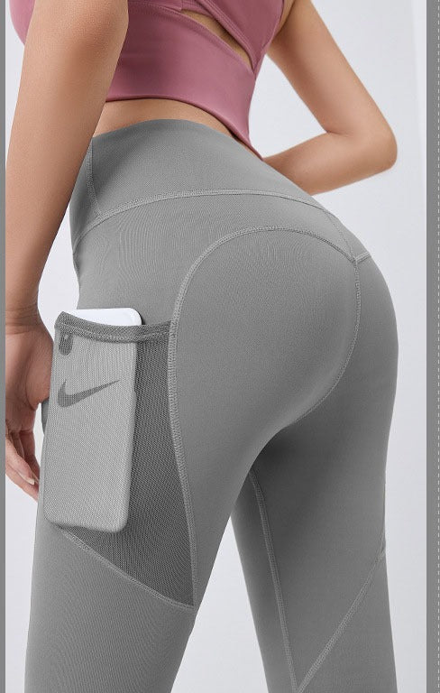 Vrouw in sportlegging met telefoon in zijvak